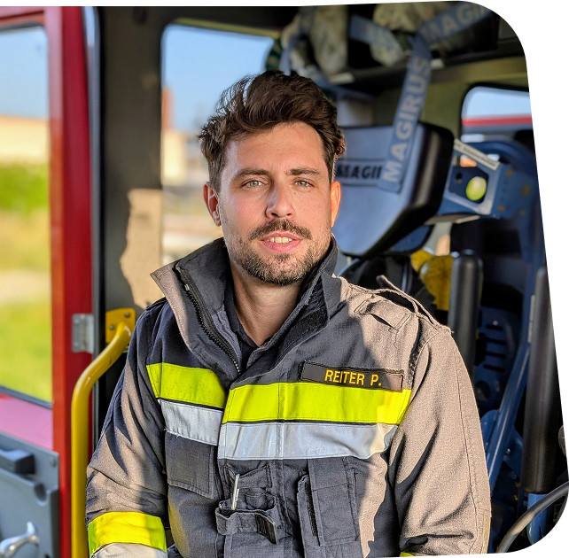 Feuerwehr Rollcontainer Paul Reiter – persönlicher Ansprechpartner für modulare Rollcontainer Paul Reiter als Feuerwehrmann neben einem Feuerwehr Rollcontainer – Ansprechpartner für individuelle Rollcontainerlösungen.